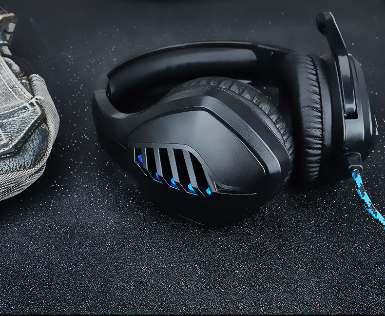 Black-blue wired gaming headset with microphone on a desk setup